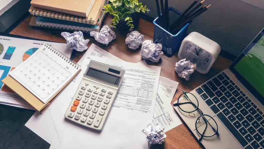 Person doing bookkeeping with receipts and a laptop