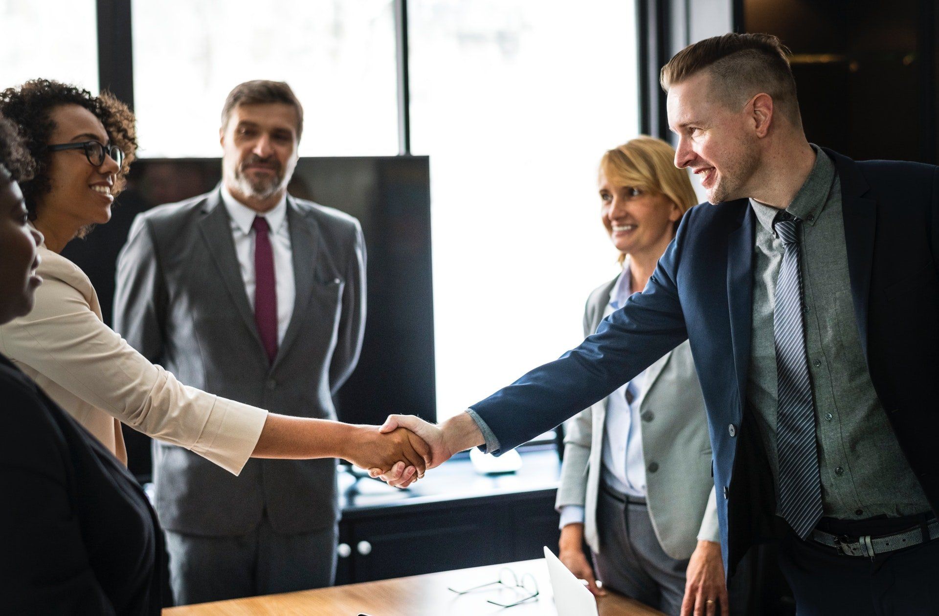 Business people shaking hands across a conference table